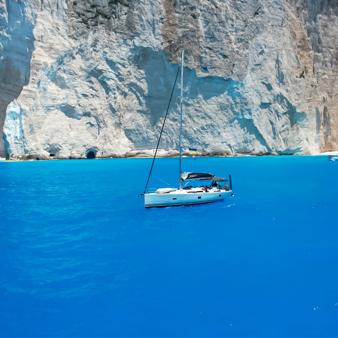 Yacht vacation in Greece, Lefkada (Lefkas) Island, Ionian Islands. Sailing through turquoise sea waters, scenic bays, mountain landscapes and summer holidays by the sea. Yachting in Greece, yacht trip, sailing holiday, sea travel, marine tourism, beautiful Greek coastline and Mediterranean travel destination.